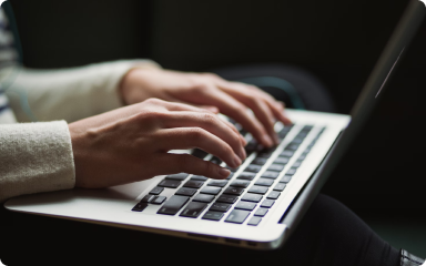 Hands typing on a laptop keyboard